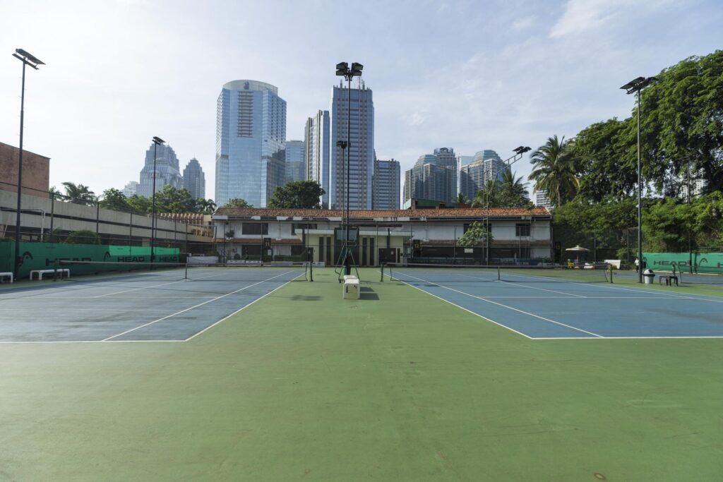 2 tennis courts with view of buildings in scbd at the sultan hotel